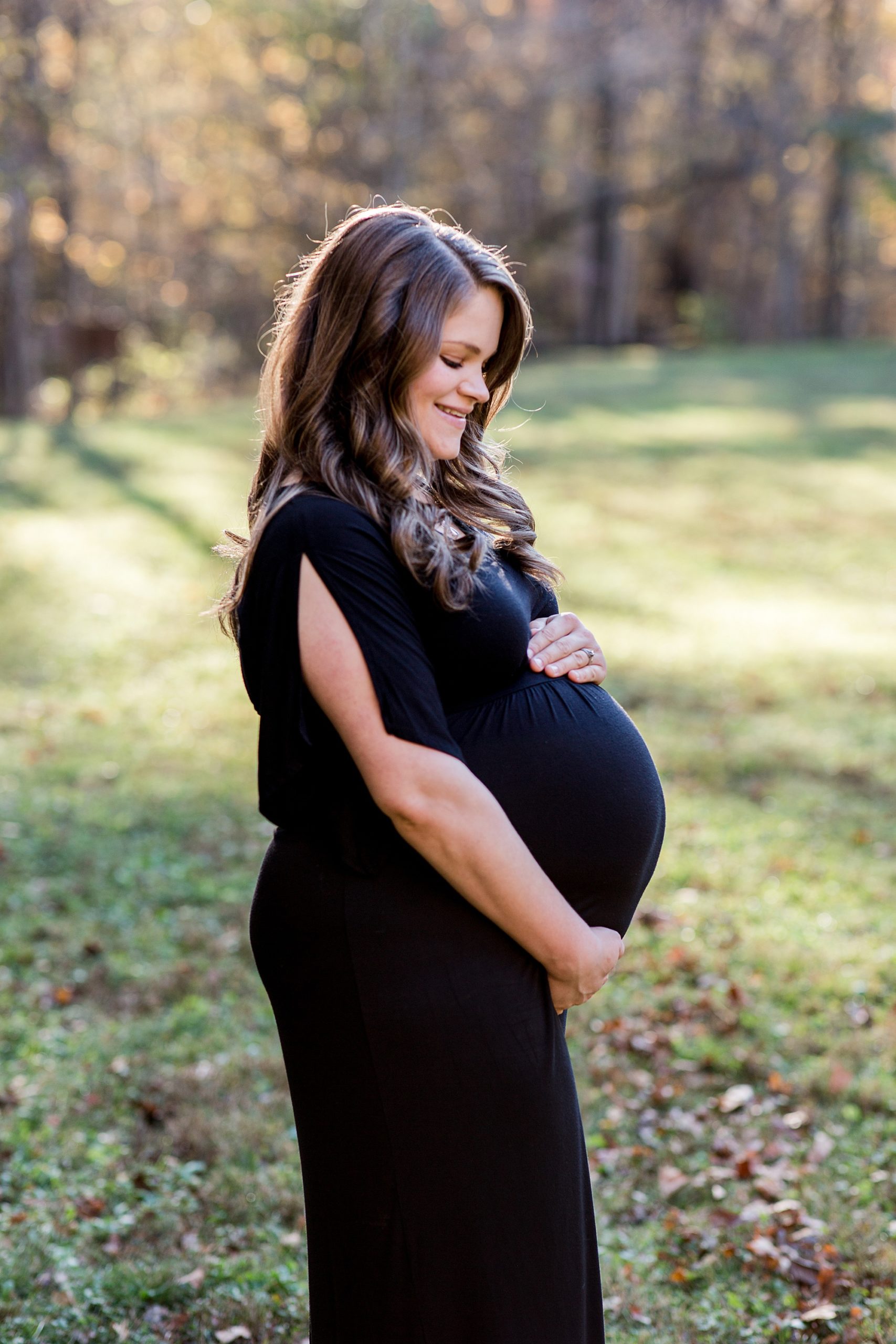 expecting mother holds belly during Montgomery Bell State Park Maternity Session