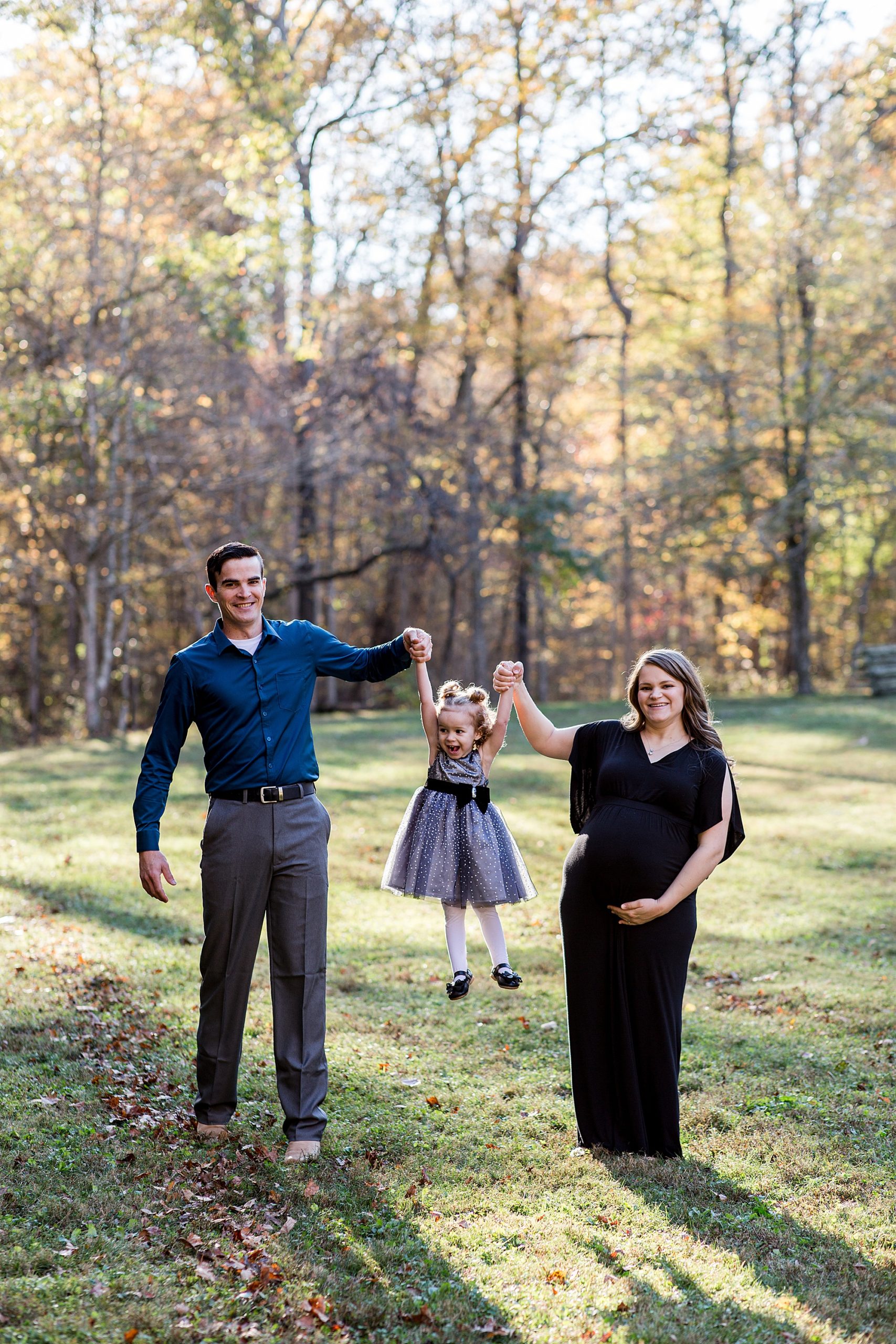 parents swing toddler daughter during family portraits at Montgomery Bell State Park