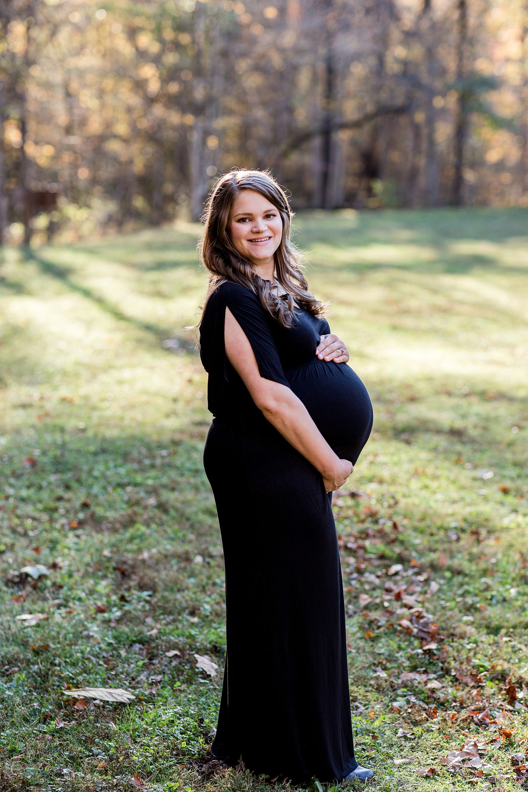 mom stands with hands on her belly during Montgomery Bell State Park maternity session