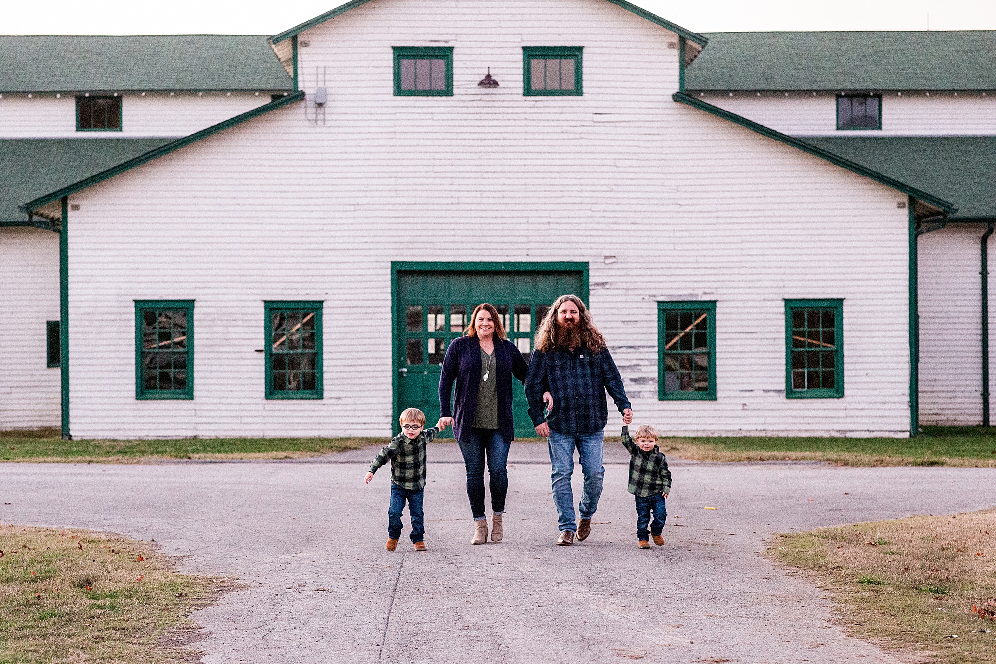family of four walks by white barn at Harlinsdale Farm