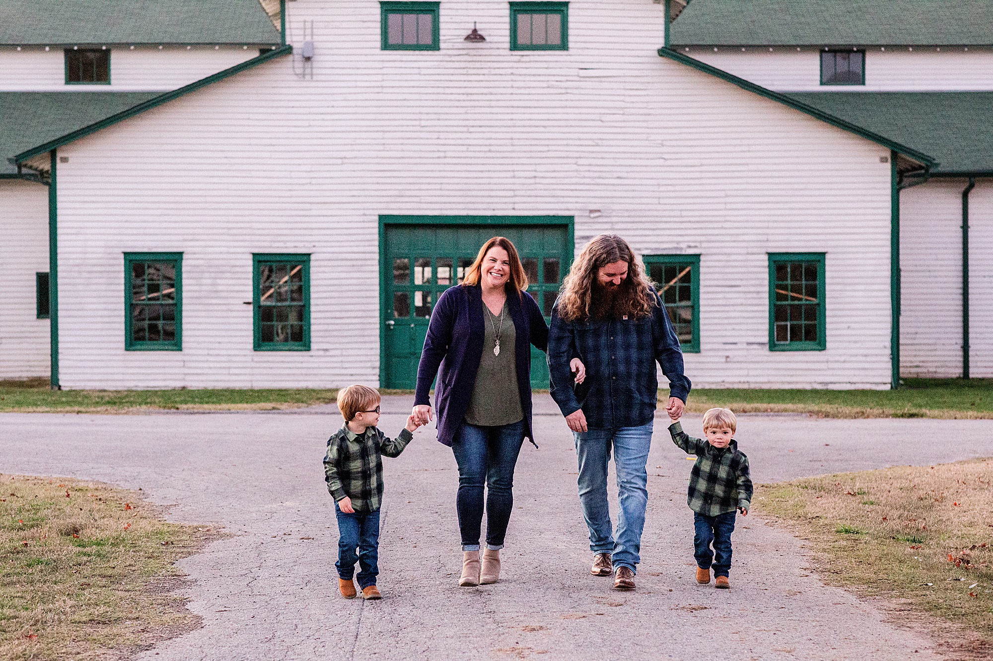family walks by white and green barn at Harlinsdale Farm 