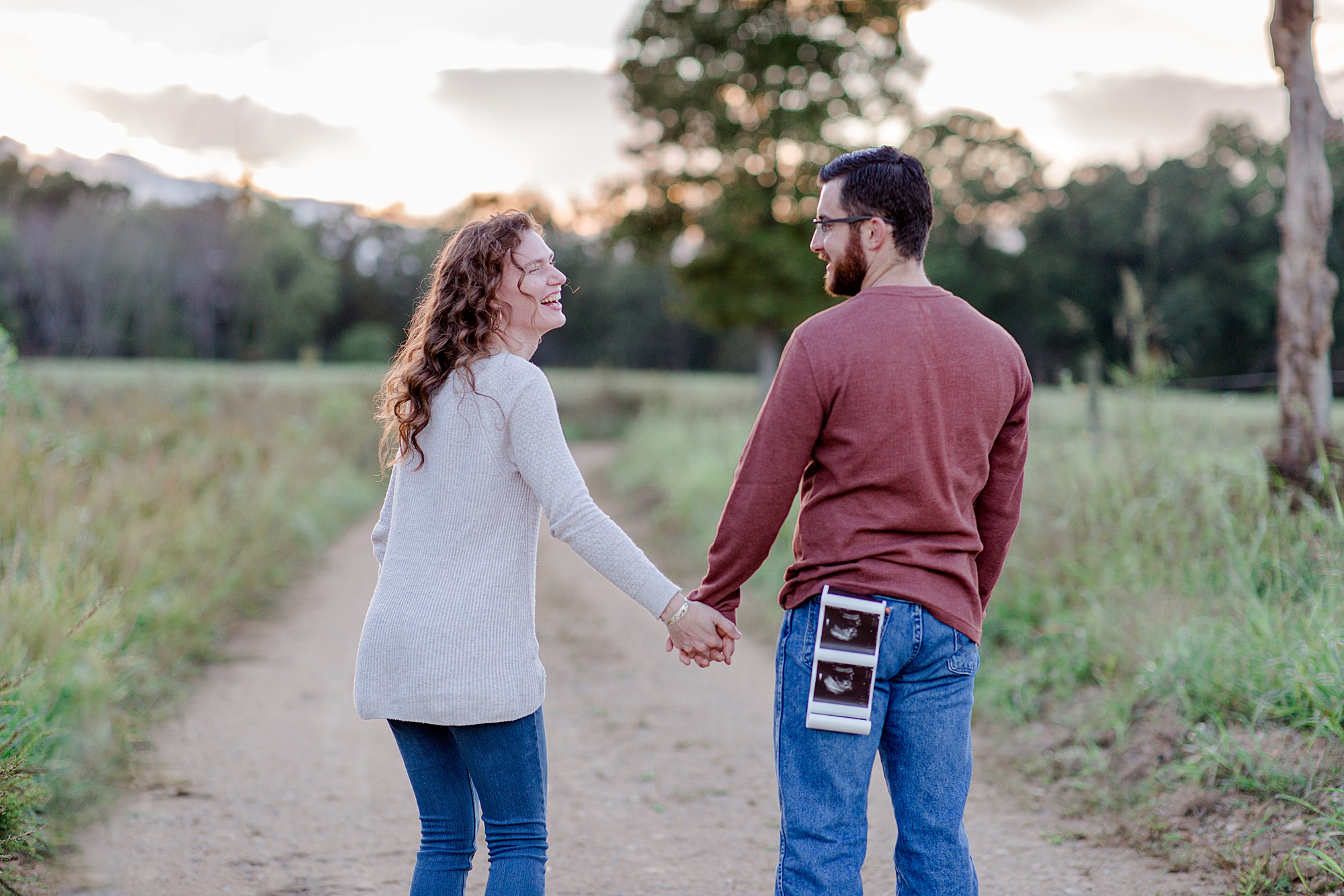 husband and wife laugh together during Pregnancy Announcement in Hickman County, TN