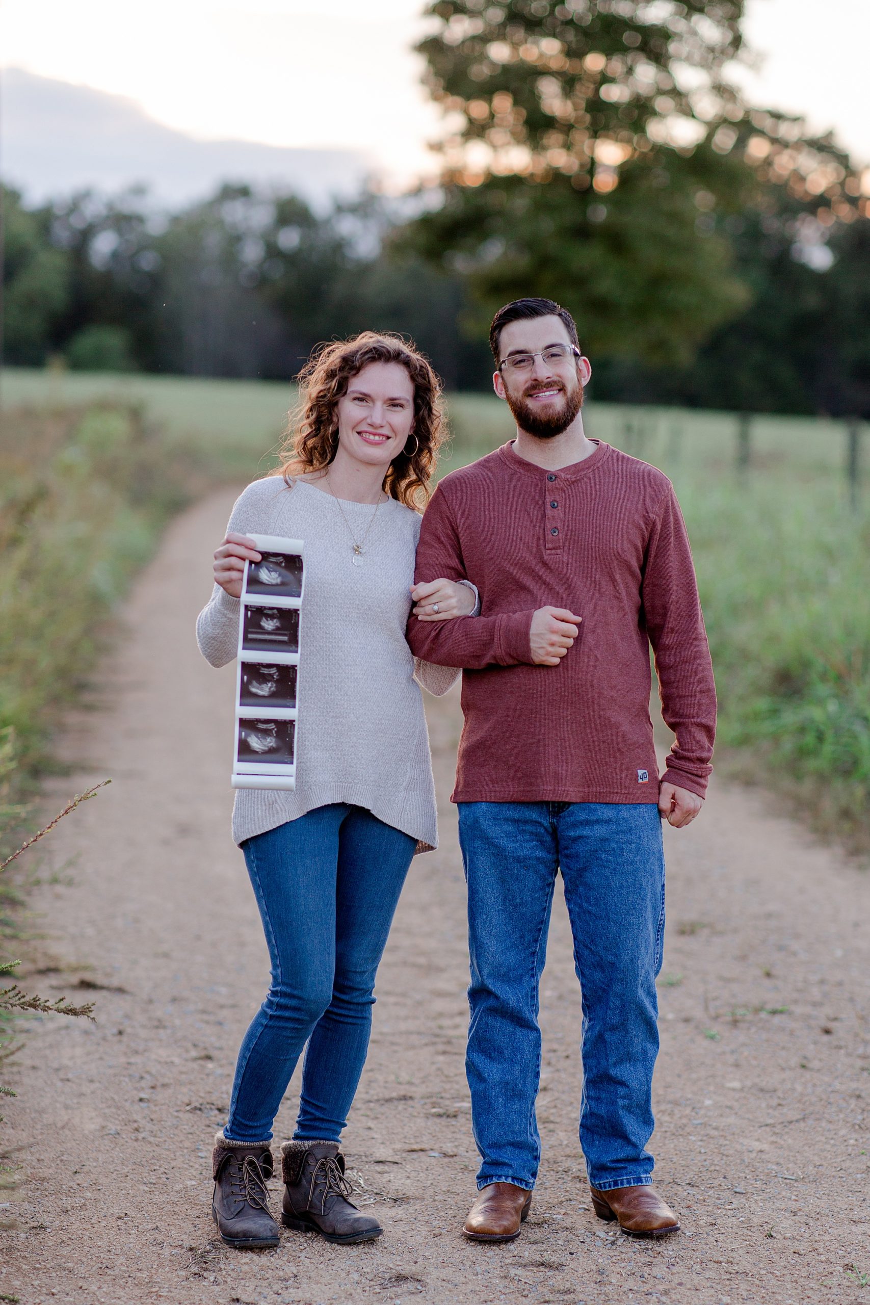 couple stand together holding sonogram during Pregnancy Announcement in Hickman County, TN