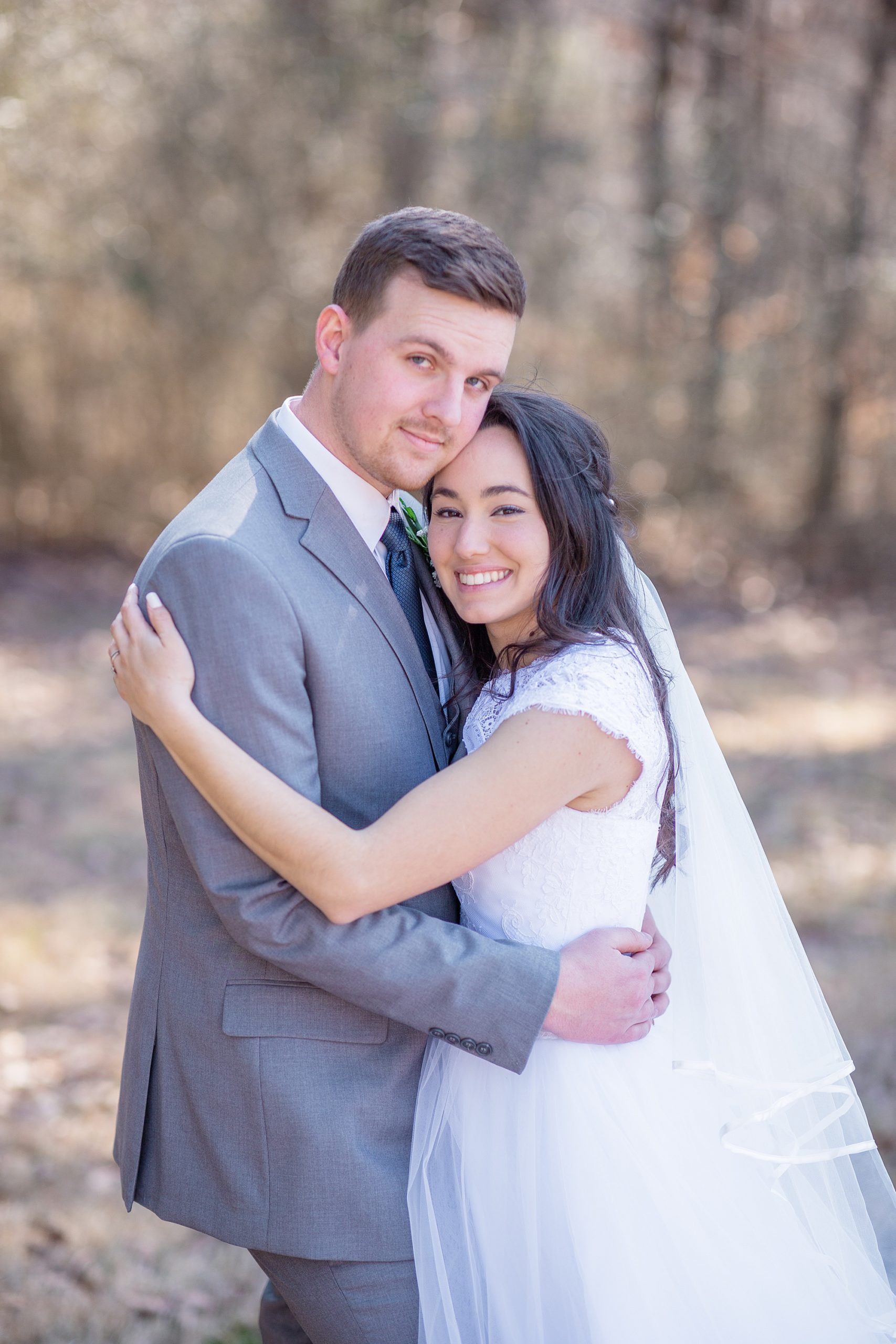 bride and groom hug together during wedding photos