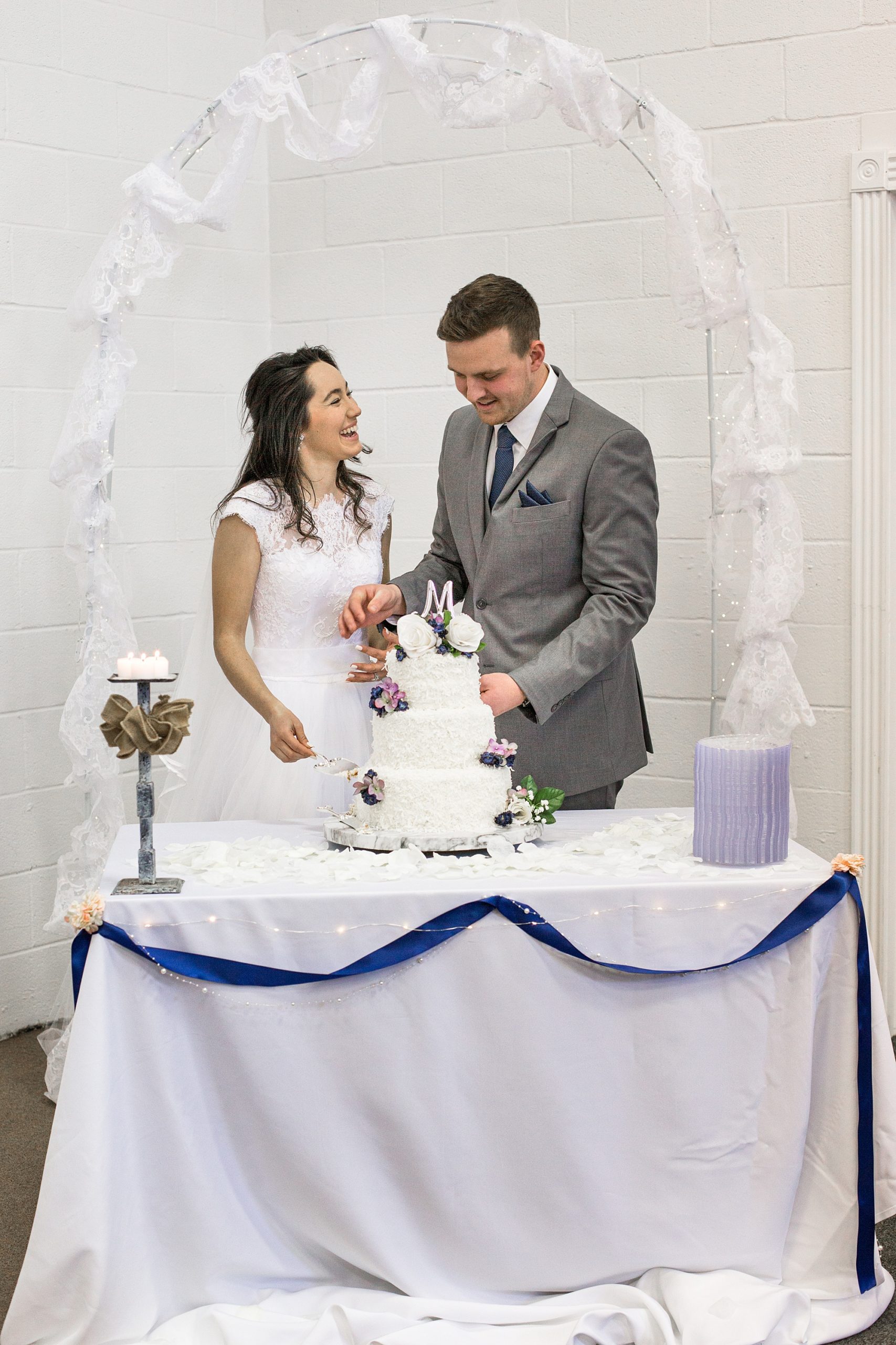 newlyweds cut wedding cake together during winter wedding in Middle Tennessee