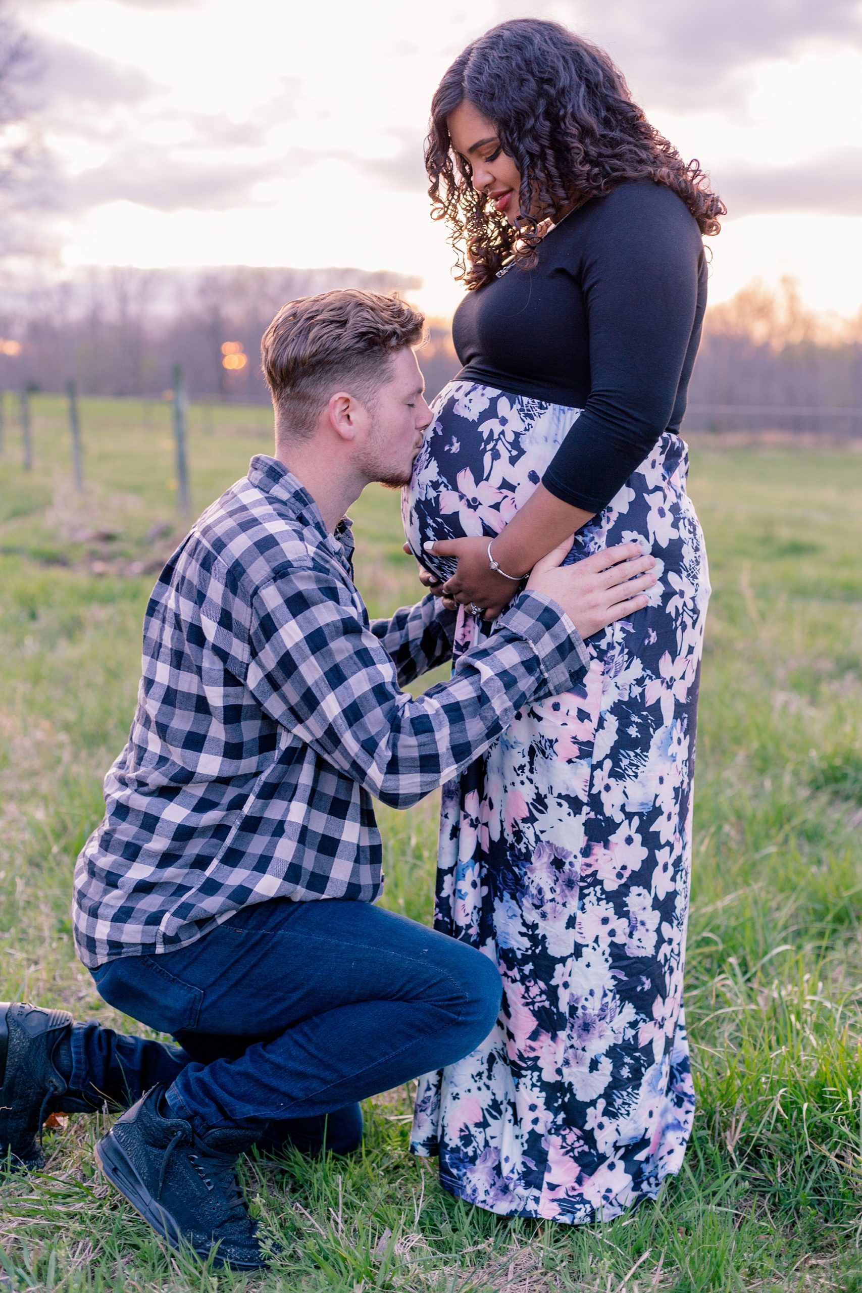 expecting dad kisses mom's belly during  sunset maternity session in Lyles TN