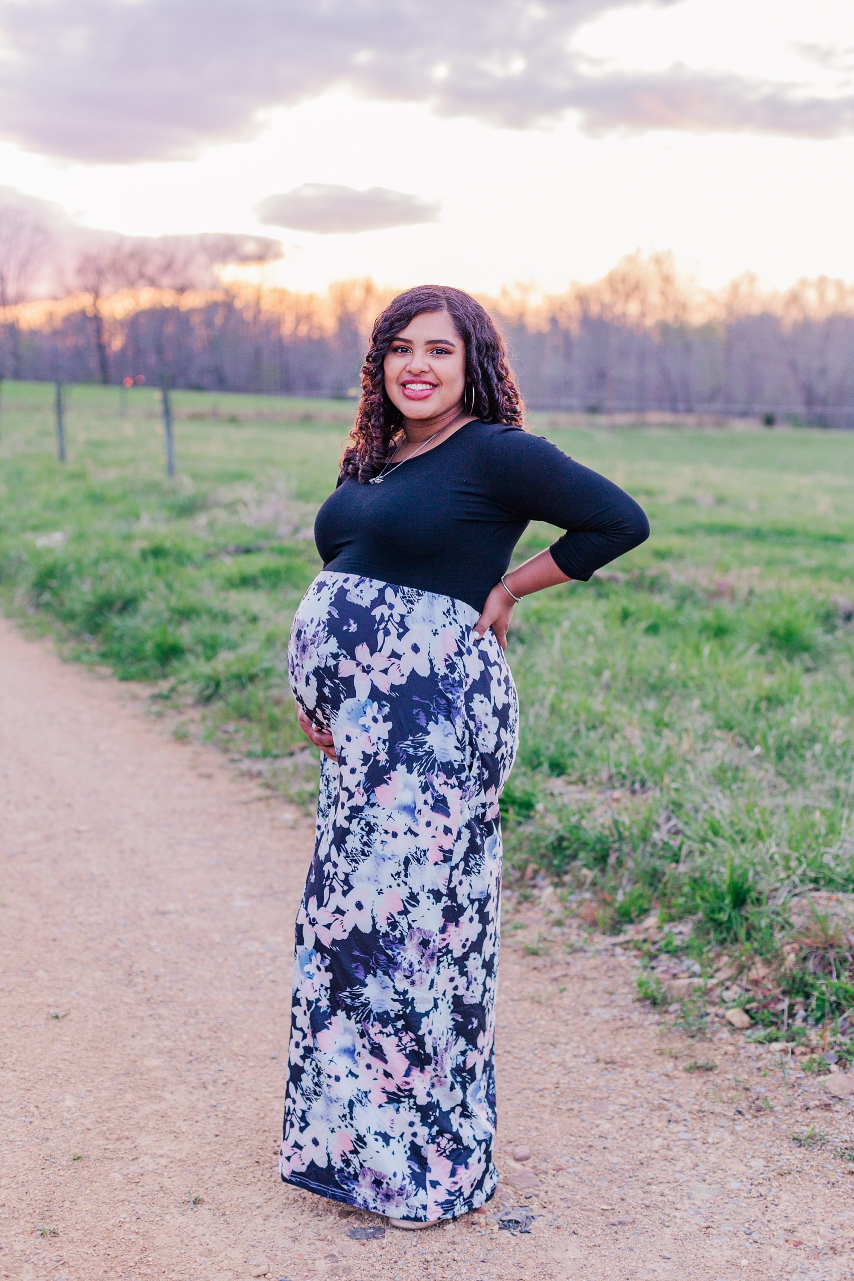 woman stands holding baby belly during maternity photos in Lyles TN