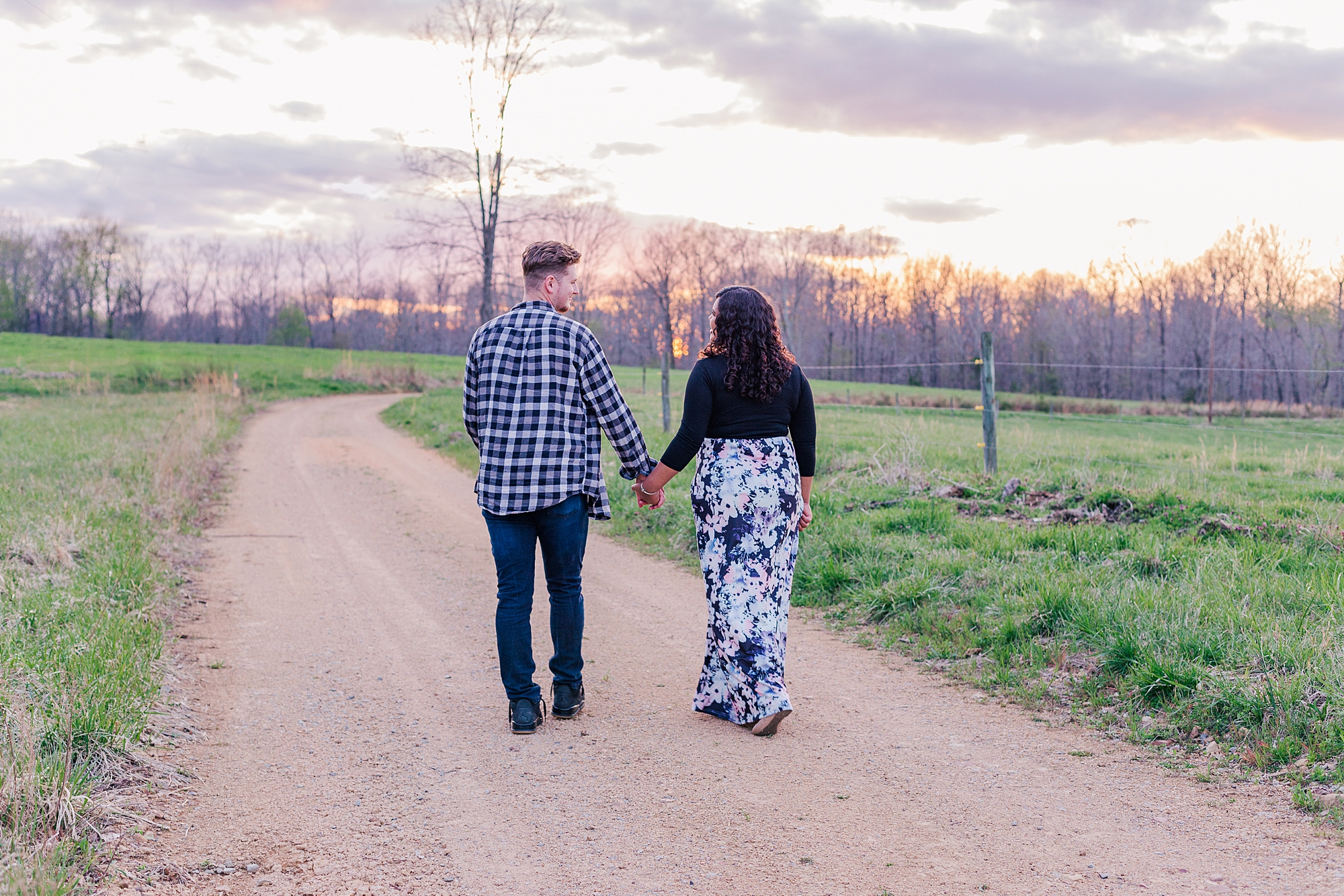 expecting couple holds hands walking down pathway in Lyles TN