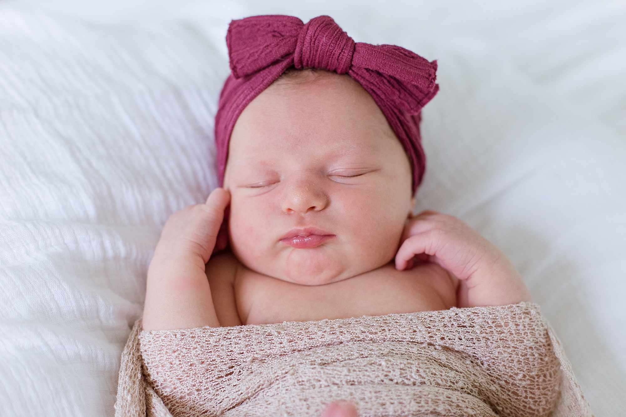 baby sleeps in red headband during newborn photos 
